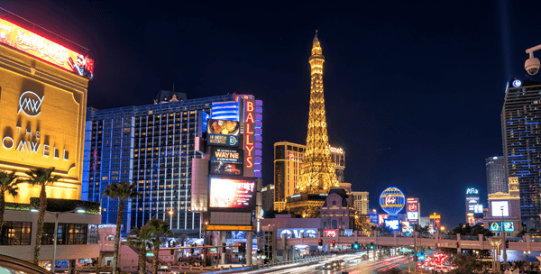 Las Vegas Strip at night with illuminated casino resorts, neon lights and traffic.