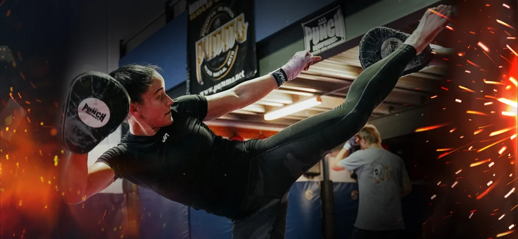 MMA fighter Chelsea Hackett in training executing a kick move.