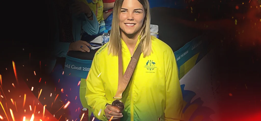 Taylah Robertson holding her gold medal that is around her neck at the Commonwealth Games.