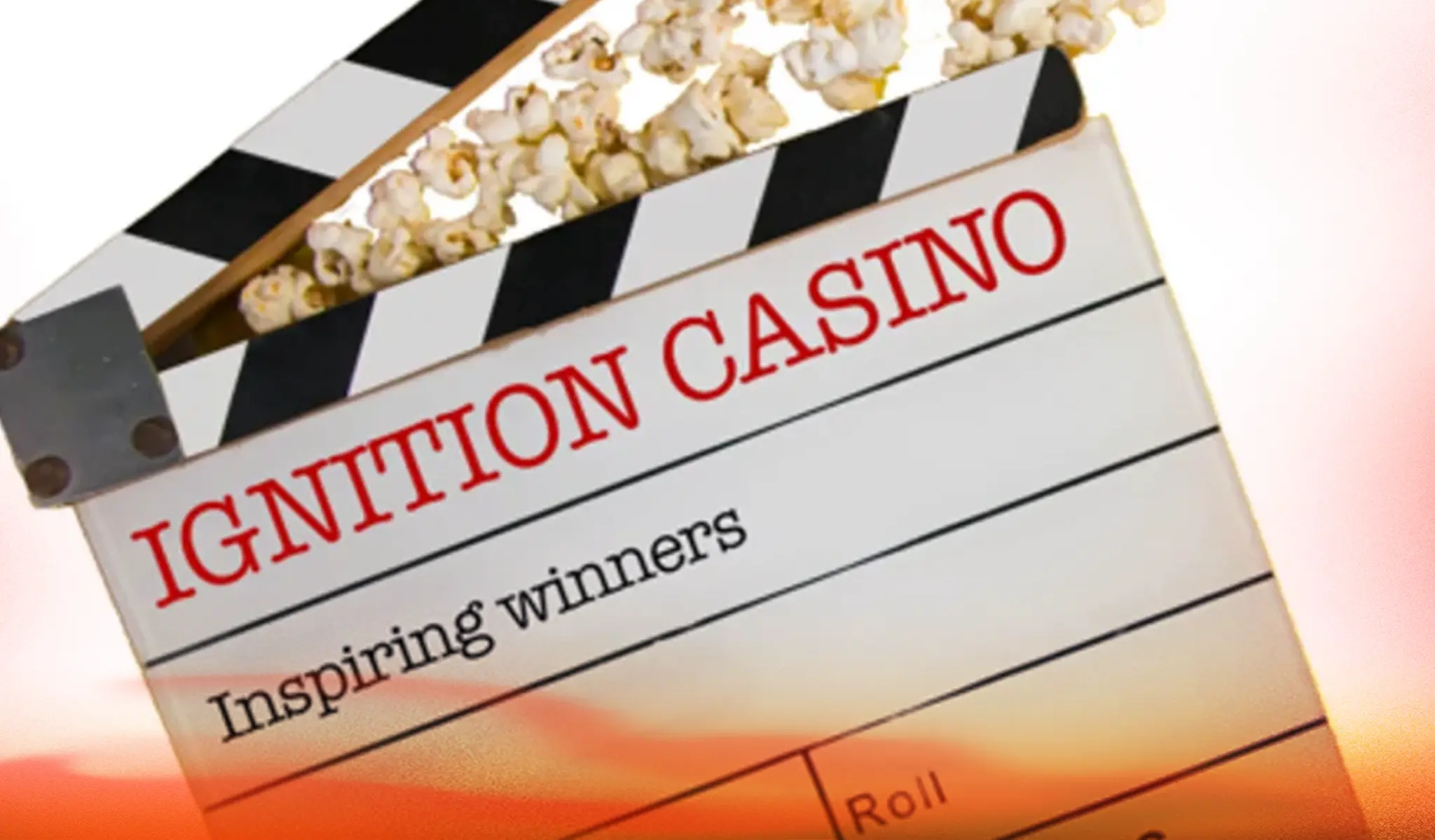 Clapperboard with "IGNITION CASINO" and popcorn on top, sunset backdrop.