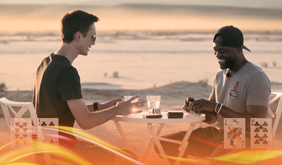 Casino King and Crazy Sixes playing poker at a small table in a desert setting, with cards visible and a sunset in the background.