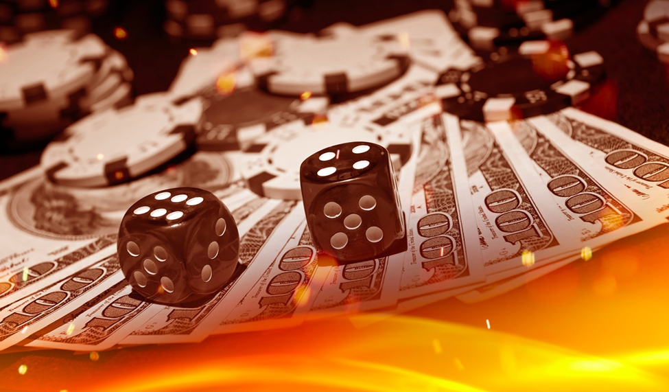 Two black dice resting on a stack of $100 bills surrounded by poker chips and a glowing orange lighting effect.